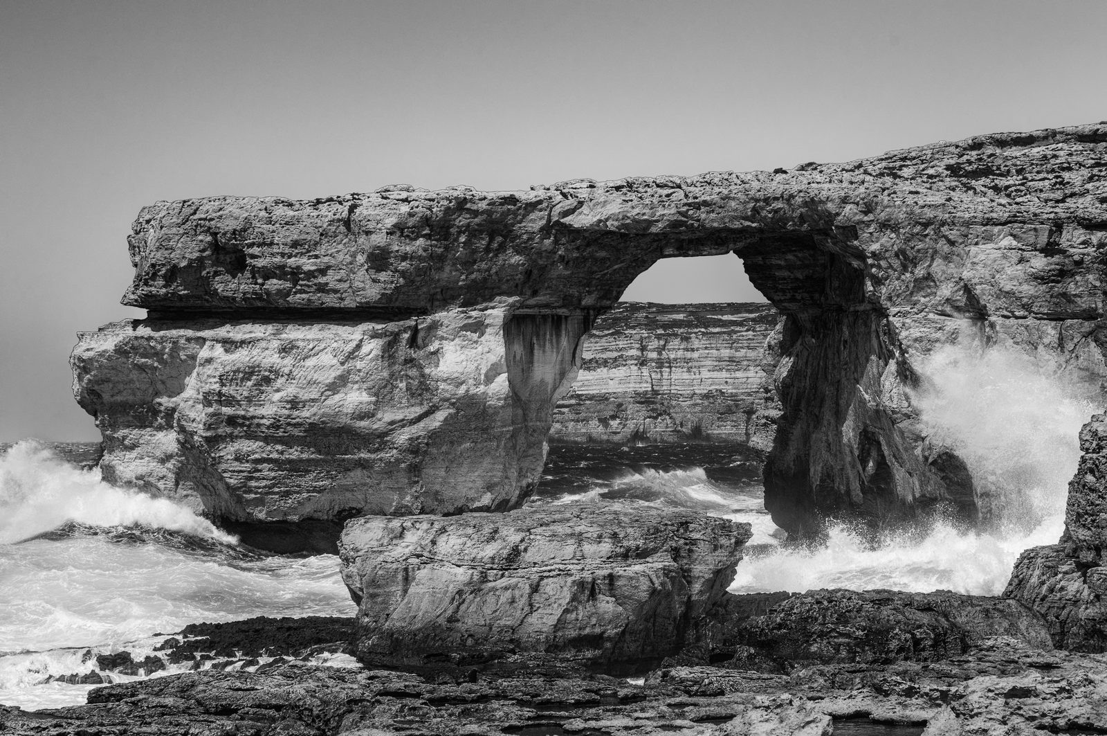 The Azure Window rock arch in black and white with a wave breaking through, Gozo, 2016