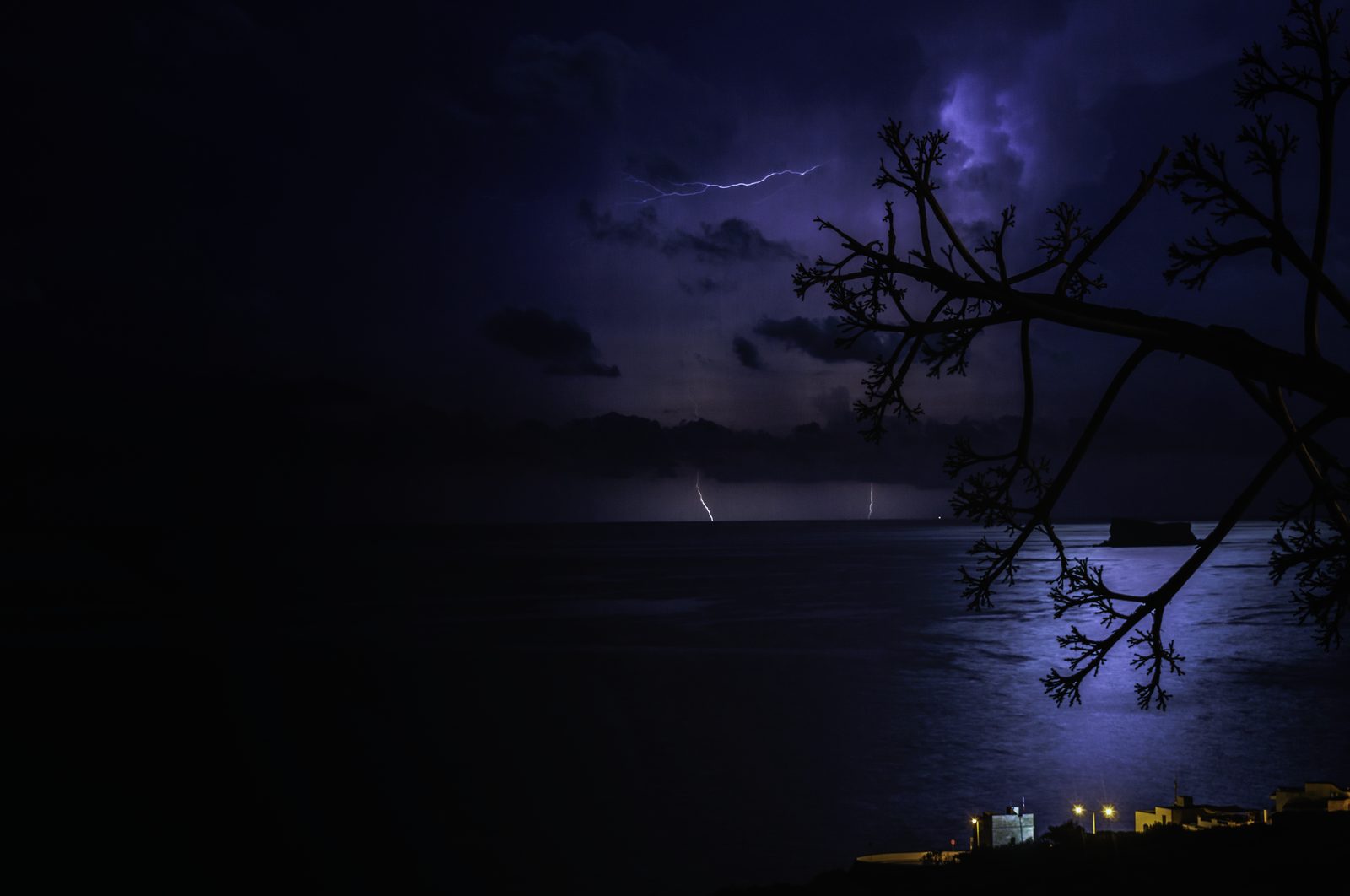 Distant lightning over the sea behind the islet of Filfla at night