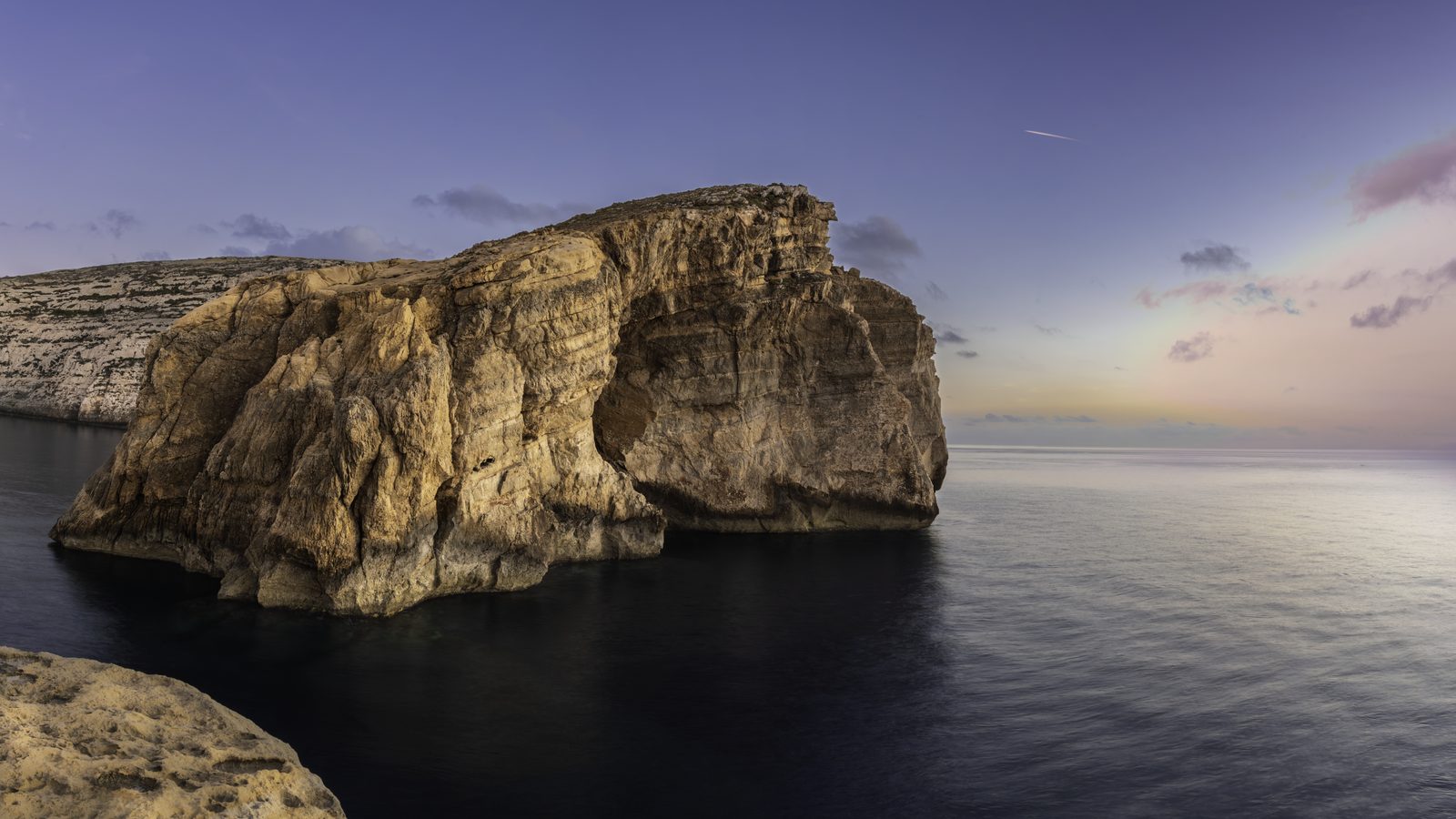 A golden light panorama over Fungus Rock and the Dwejra bay, Gozo