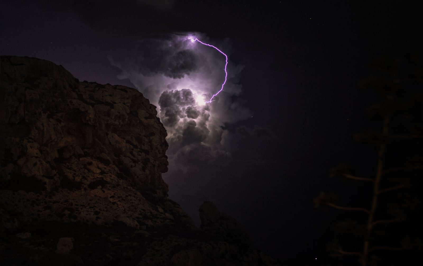 A lightning bolt inside a glowing storm cell over the sea at Il-Munqar, Malta