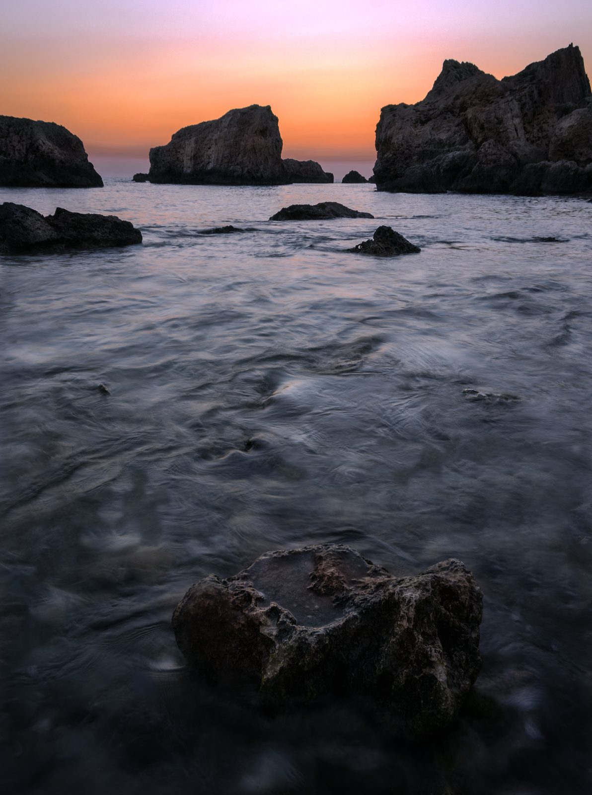 Rounded boulders on the shore in pastel light at Majjistral, Malta