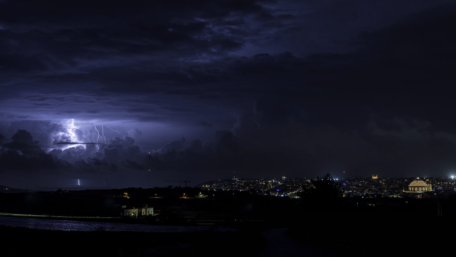 Lightning storm over the rooftops of Mosta at night