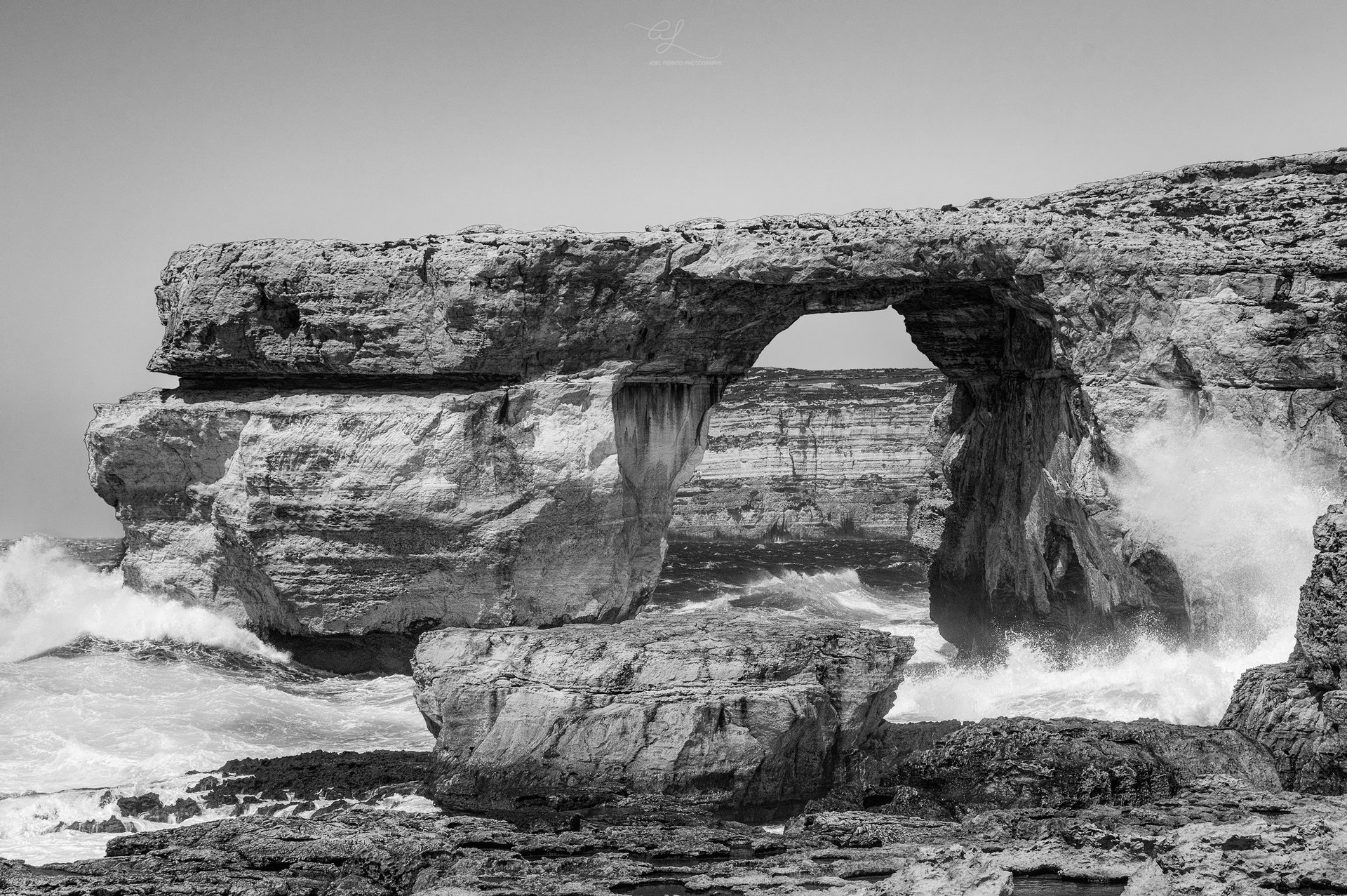 The Azure Window rock arch in black and white with a wave breaking through, Gozo, 2016