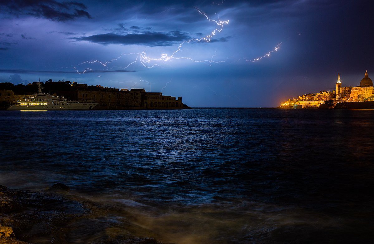 A lightning crawler crossing the sky above the Grand Harbour and Valletta at night